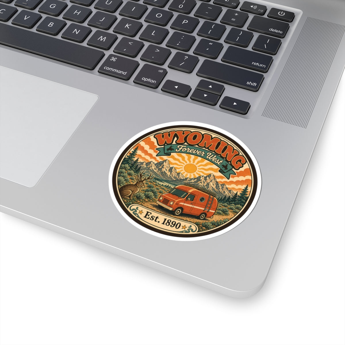Round kiss-cut sticker with Wyoming Forever West design, orange van, mountains, and sun