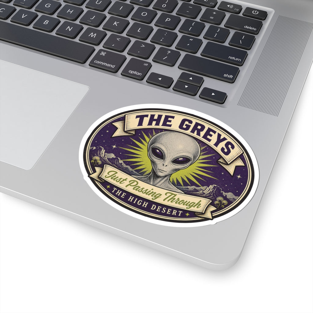 Circular kiss-cut alien sticker on laptop, purple backdrop with yellow sunburst rays