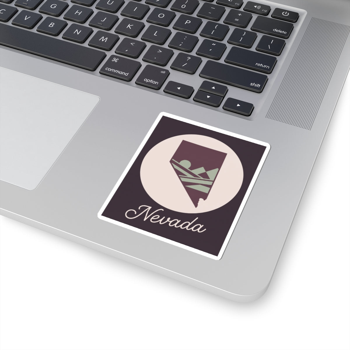 Nevada sticker with white circle and square border, purple state silhouette and script 'Nevada'