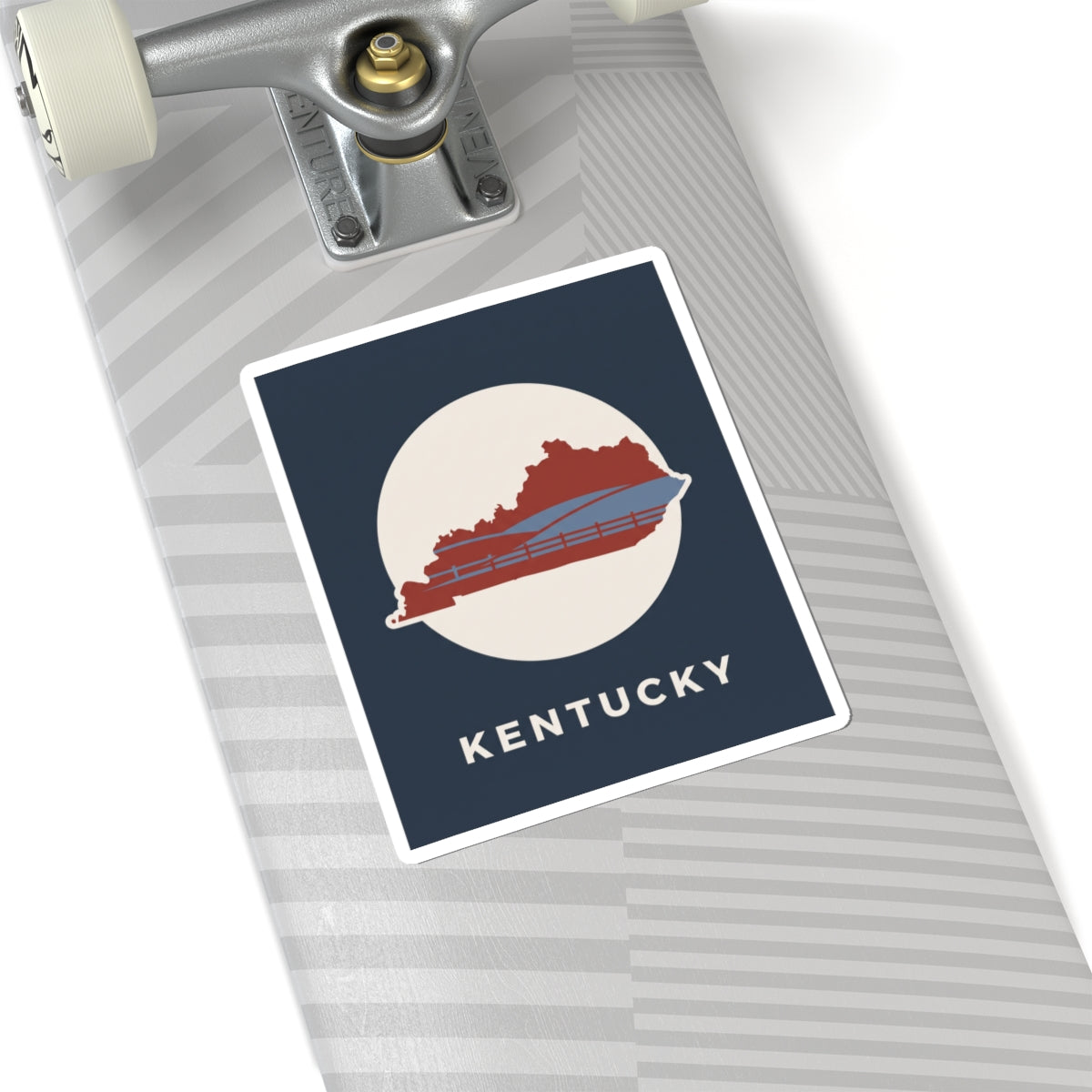 Kentucky travel decal on gray suitcase: navy square with white circle, red bridge, and KENTUCKY