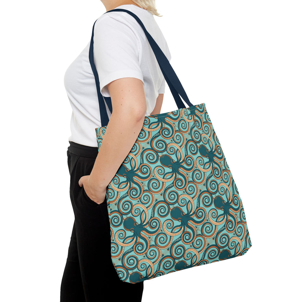 Teal octopus swirl tote bag with navy handles, angled view of ocean print.