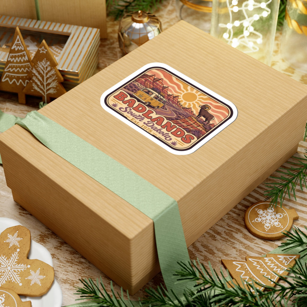 Kiss-cut sticker on gift box: camper van, bighorn sheep, desert sun waves, Badlands text