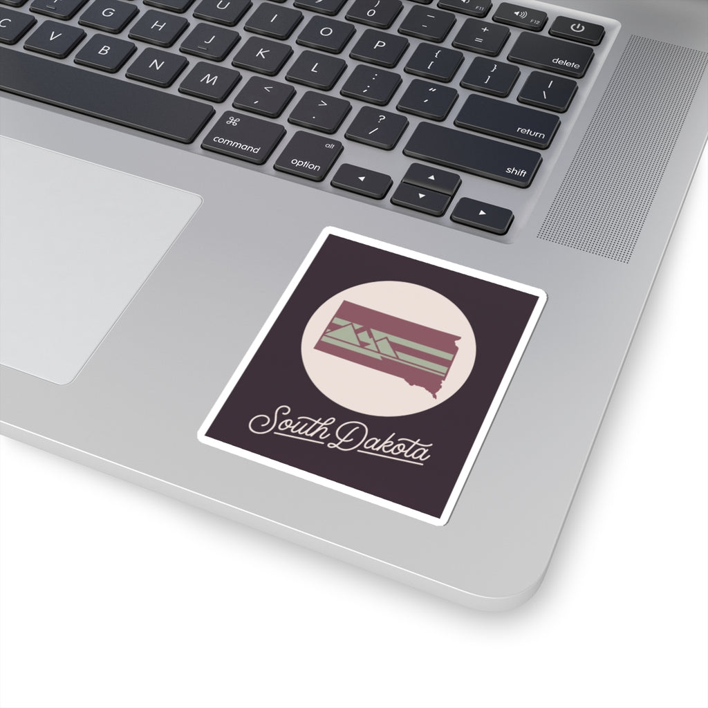 South Dakota kiss-cut decal placed on a laptop, dark purple design with cursive text