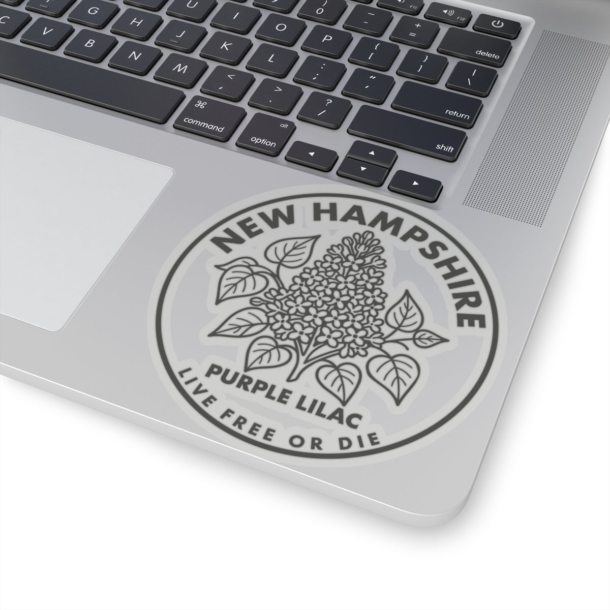 Round transparent-vinyl decal on laptop lid with purple lilac floral crest