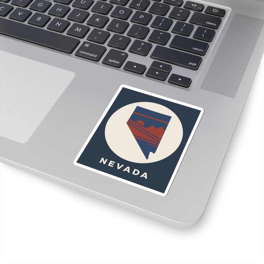 Nevada state kiss-cut sticker on a laptop lid, circular emblem with retro mountains