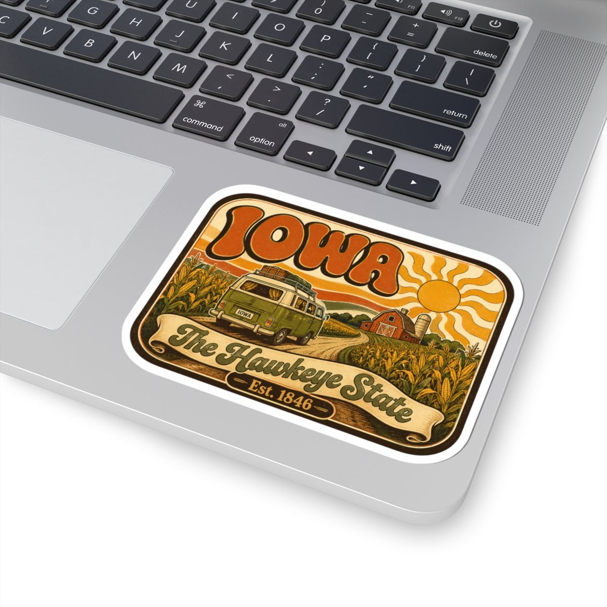 Kiss-cut Iowa retro camper sticker on laptop; “The Hawkeye State” ribbon and Est. 1846, white border