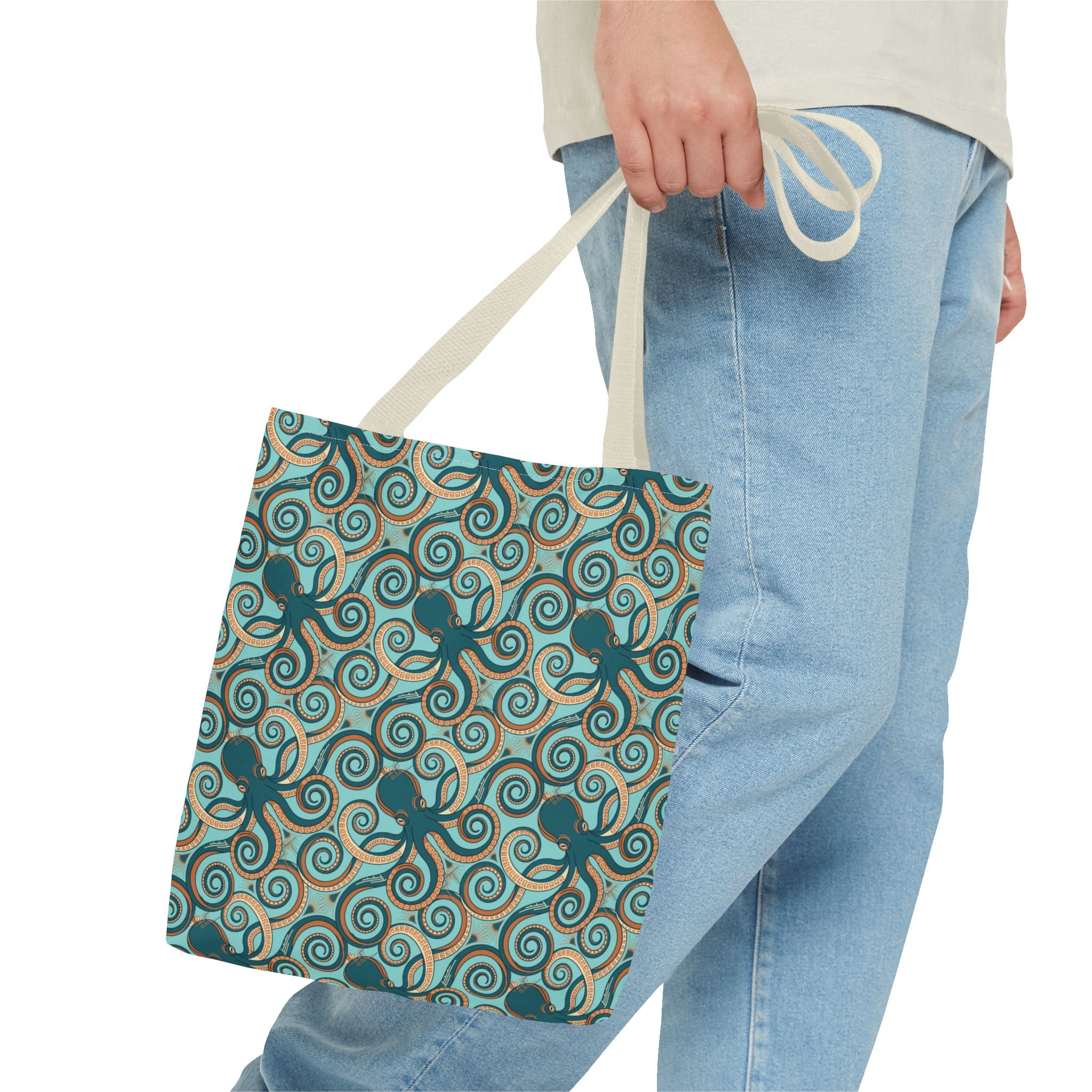 Teal octopus swirl tote bag with rope handles, held at the top.