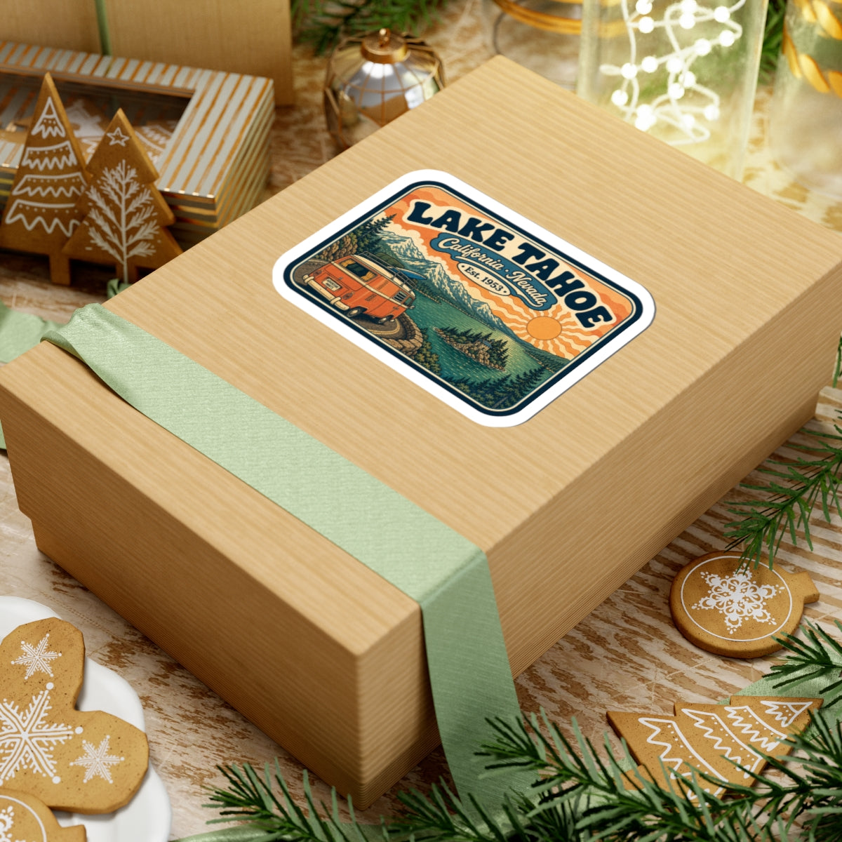 Kiss-cut Lake Tahoe sticker on a wrapped package, mountain lake and orange camper van illustration.