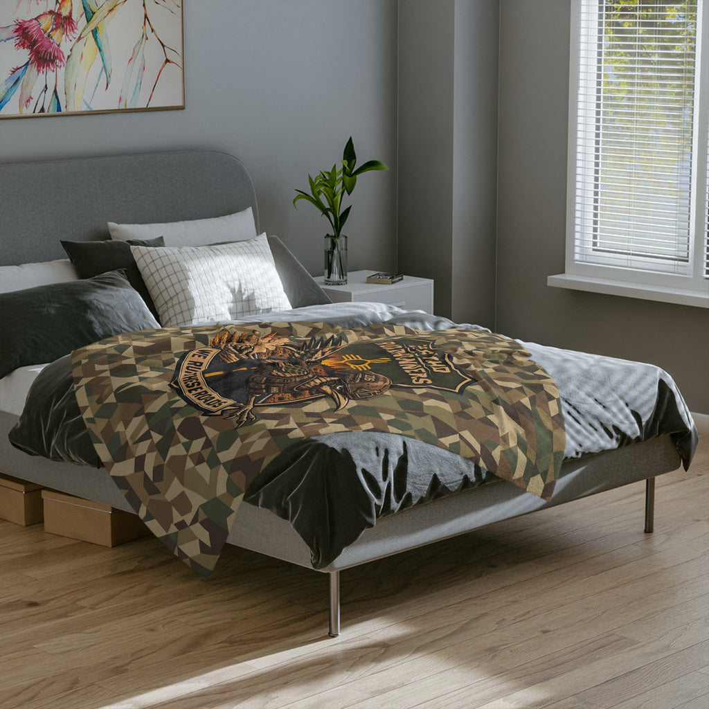 Camo microfiber blanket with large embroidered runner patch and graphic text, on bed