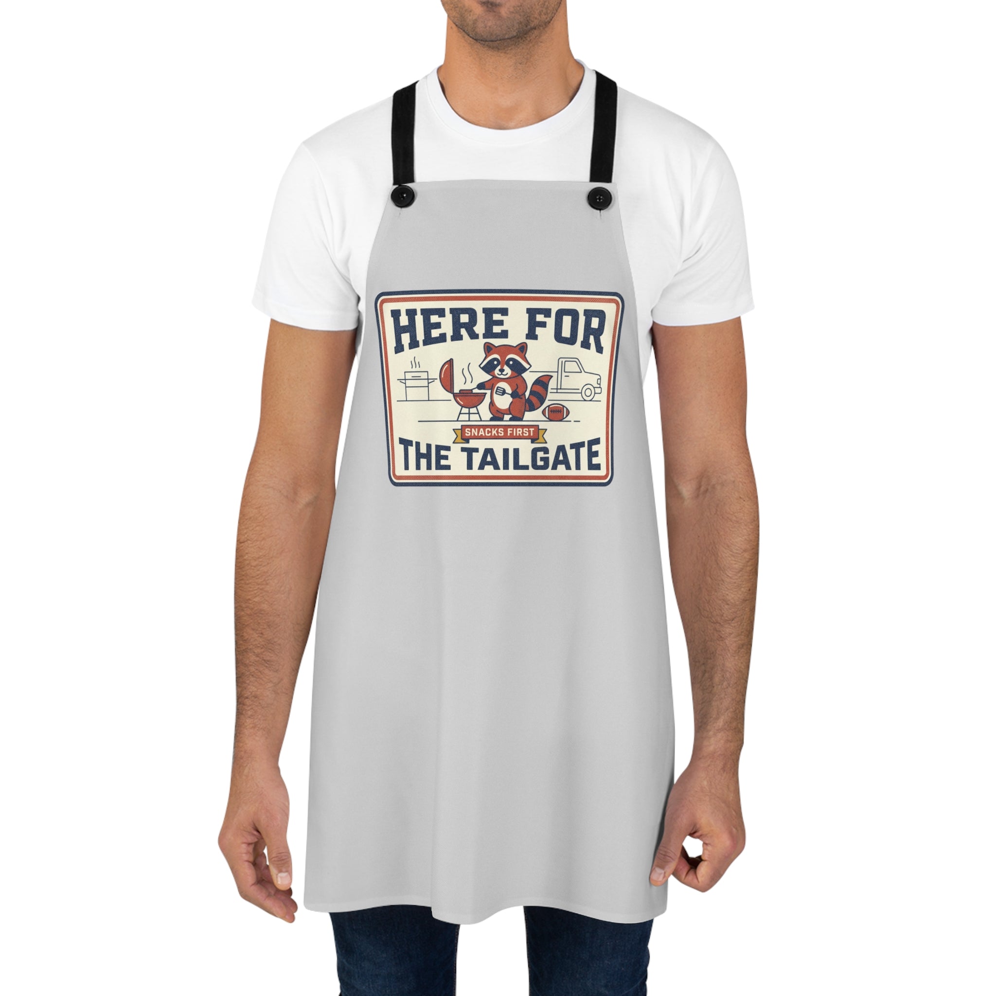 Light gray BBQ apron worn by man, black straps and 'HERE FOR THE TAILGATE' print