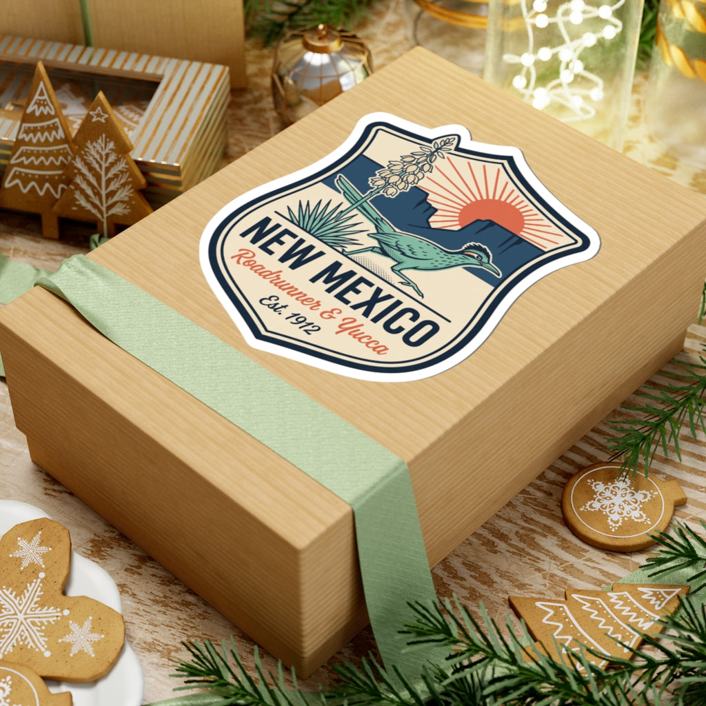 Shield badge decal on a wrapped box: roadrunner and yucca with “NEW MEXICO” lettering