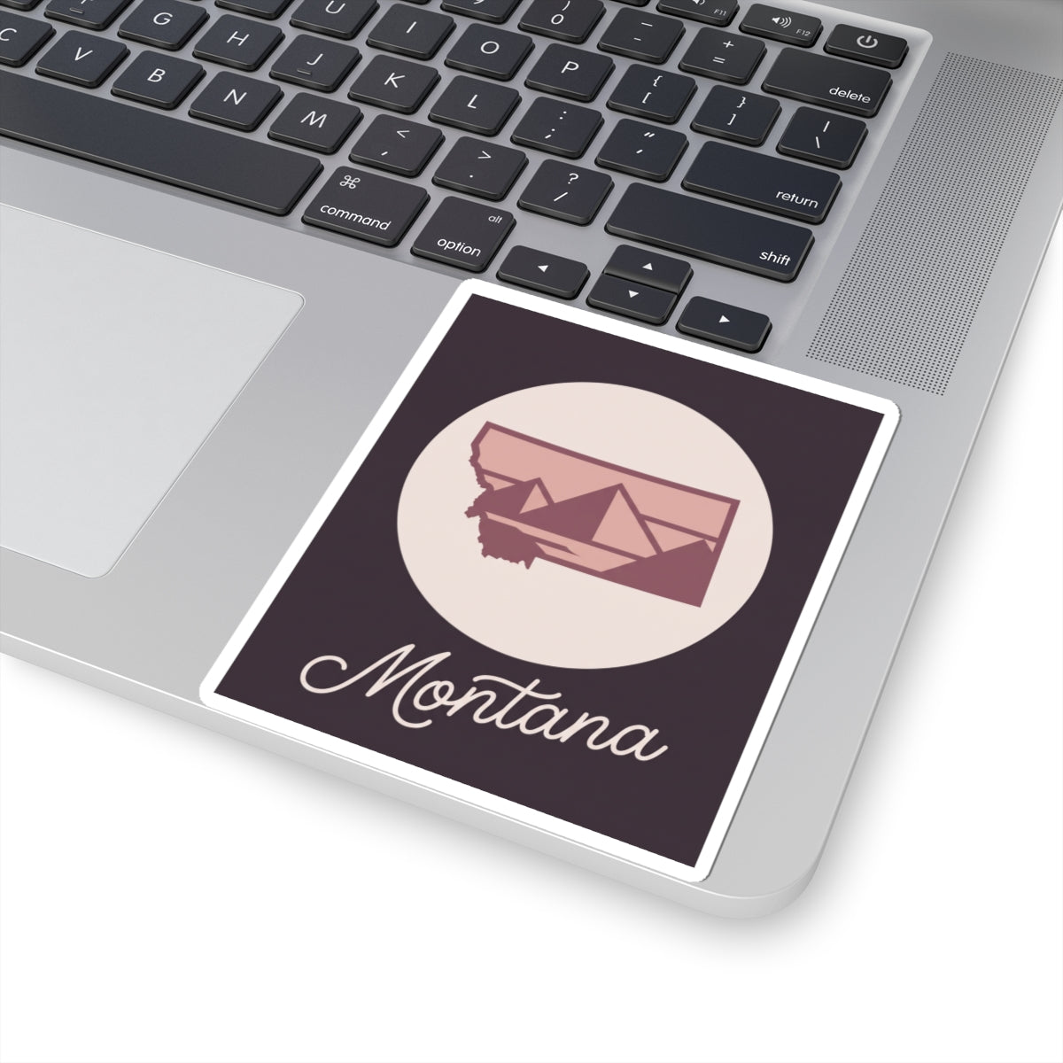 Montana state decal sticker on laptop, featuring circular mountain graphic and “Montana”