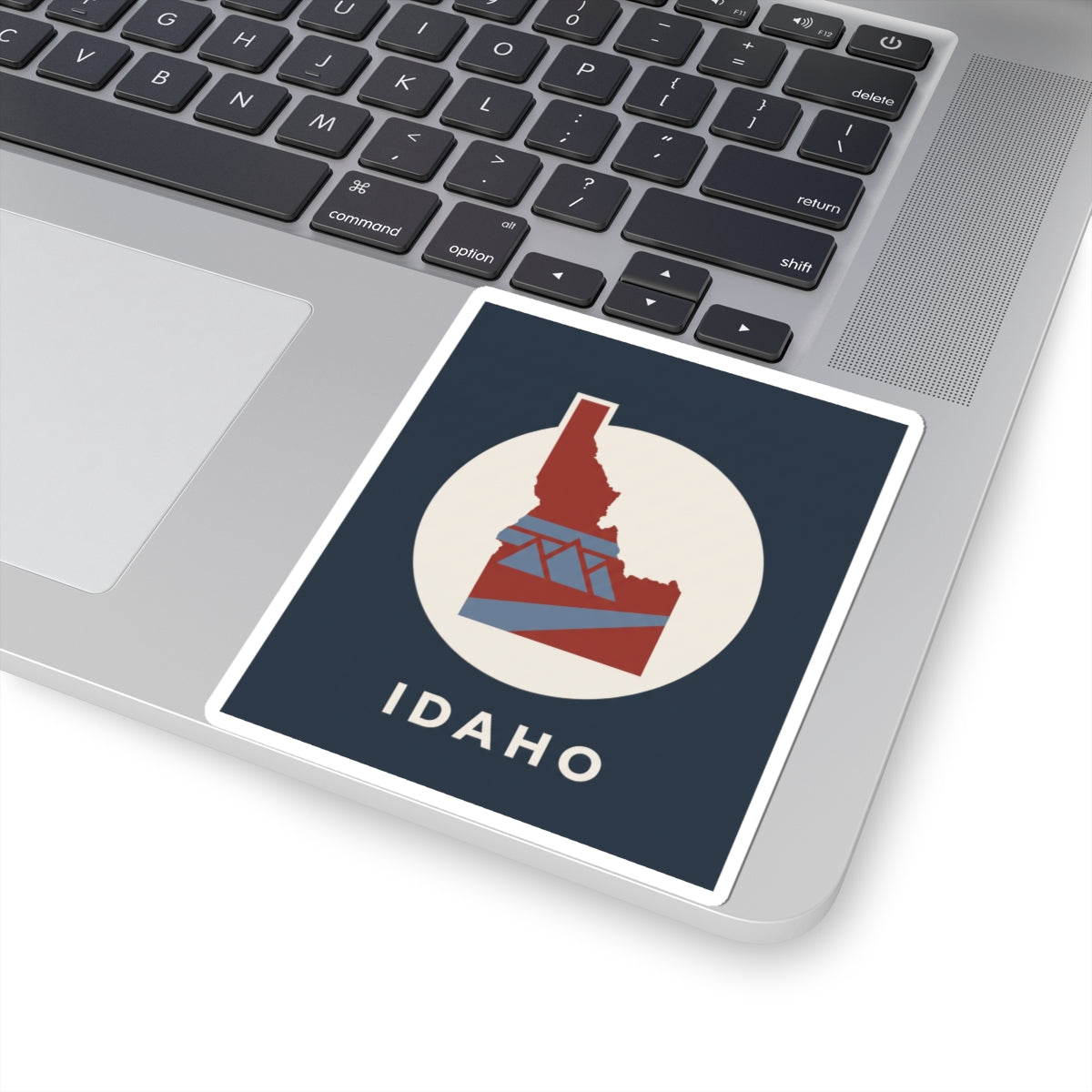 Idaho kiss-cut sticker featuring red state-and-bridge design in a white circle, IDAHO
