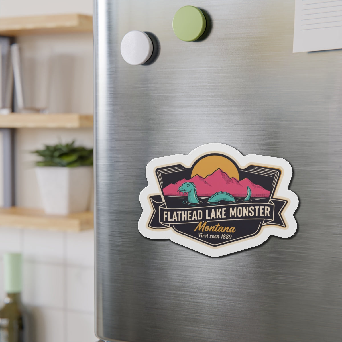 Die-cut magnet badge with Flathead Lake Monster and Montana script on stainless steel