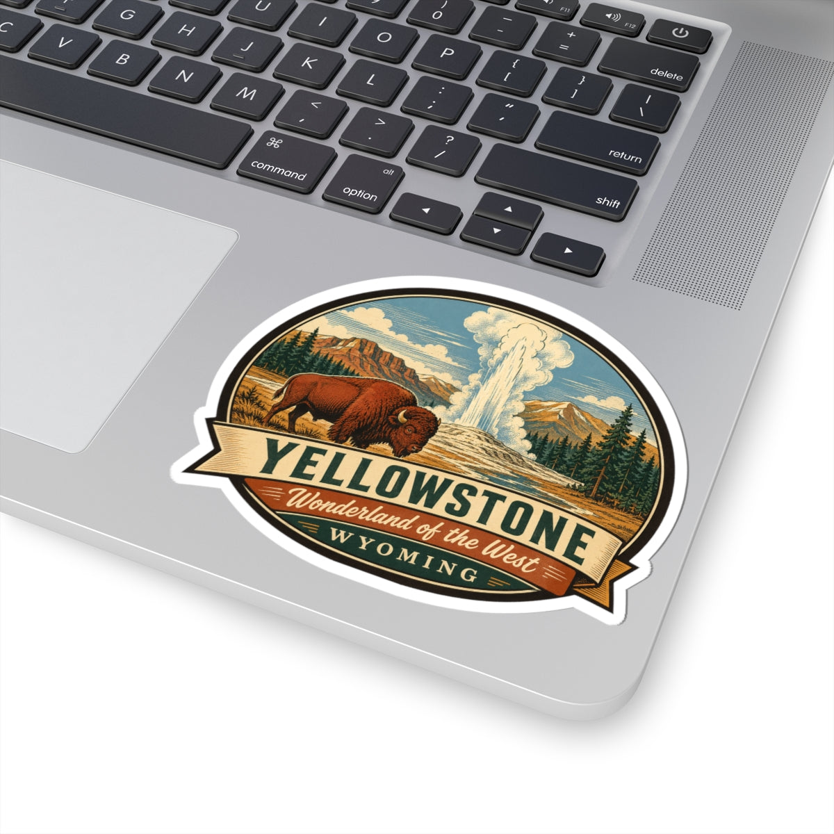 Yellowstone travel sticker on a laptop; round badge with bison, geyser, and Wyoming