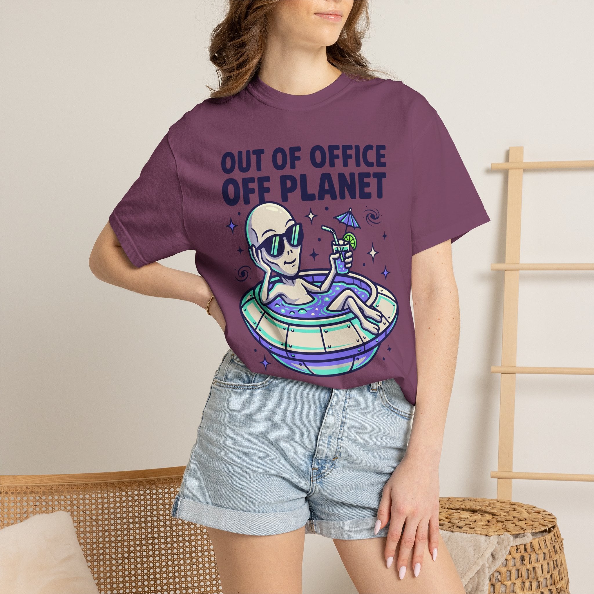 Purple crewneck T-shirt on model with alien floatie graphic and 'OUT OF OFFICE OFF PLANET'