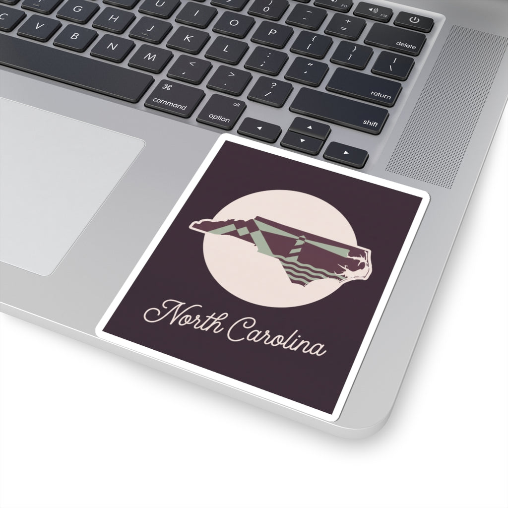 North Carolina decal sticker on laptop keyboard, purple panel with state outline and “North Carolina”