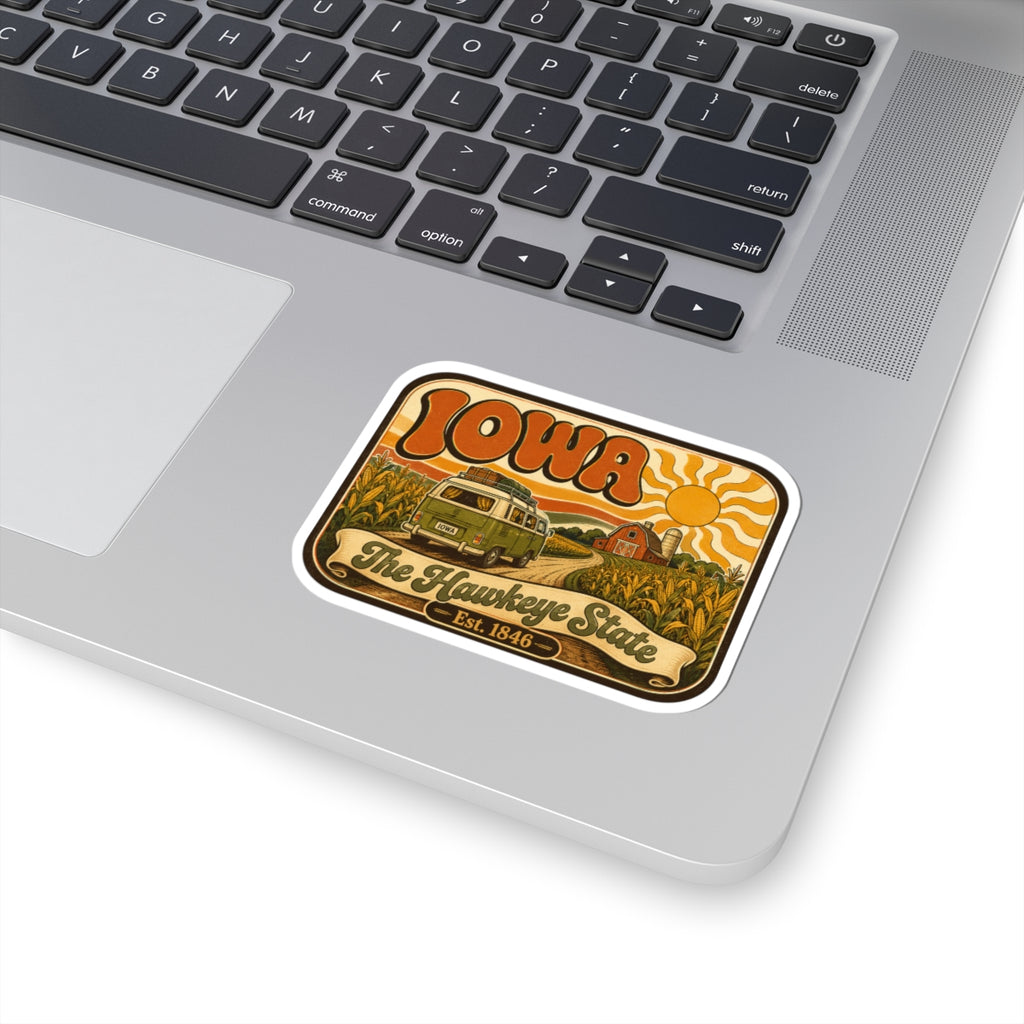 Kiss-cut Iowa retro camper sticker placed on dark keyboard; white kiss-cut border, colorful design