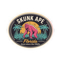 Circular Skunk Ape Florida sticker with palm trees, pink figure, and “Seen since the 1960s” text