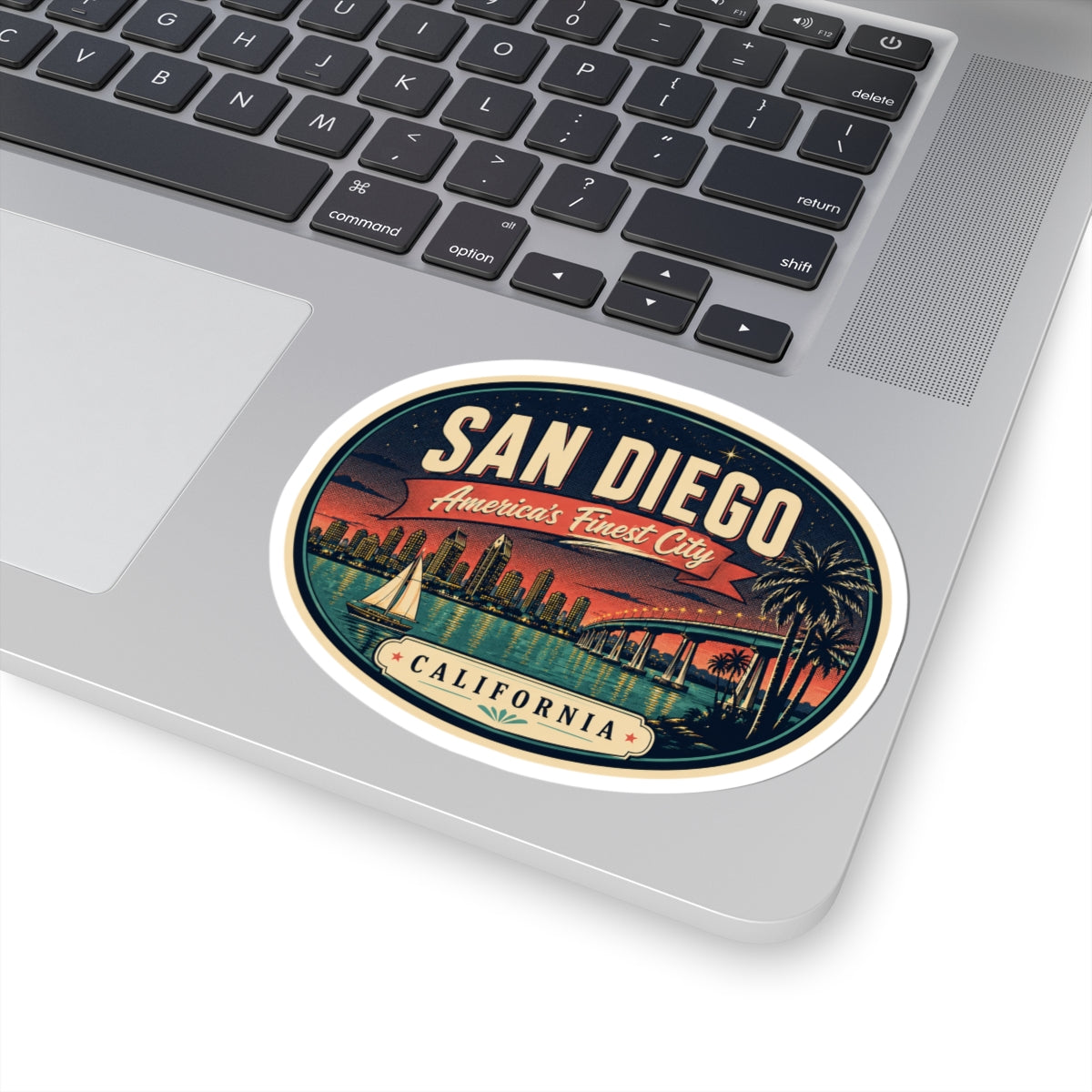 Round San Diego luggage tag sticker on a laptop keyboard, featuring the California badge