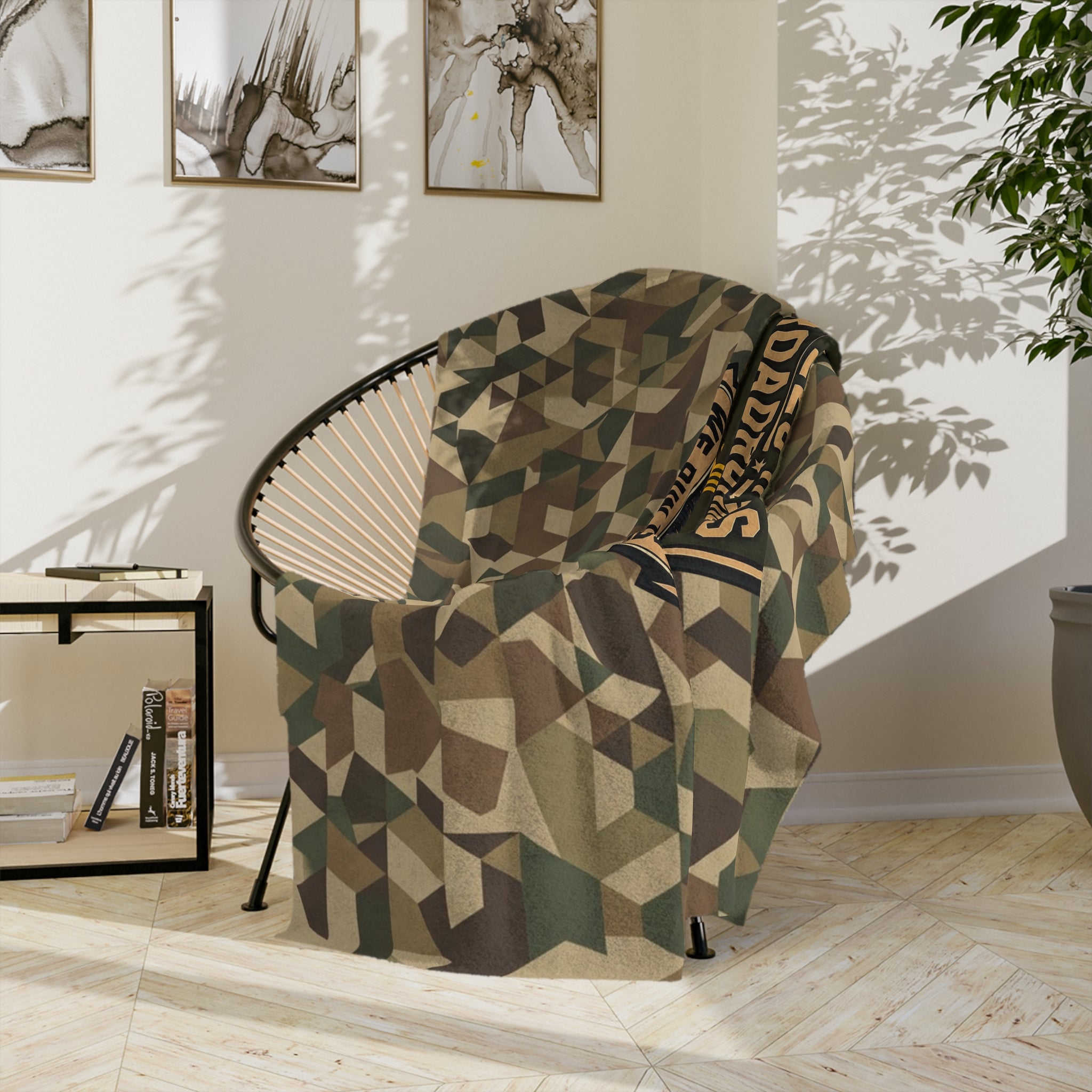 Geometric camo microfiber blanket draped on chair with embroidered border patch