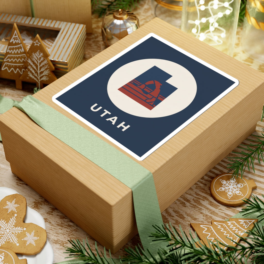 Utah arch logo sticker on gift wrap: navy square, white circle, red emblem, "UTAH"