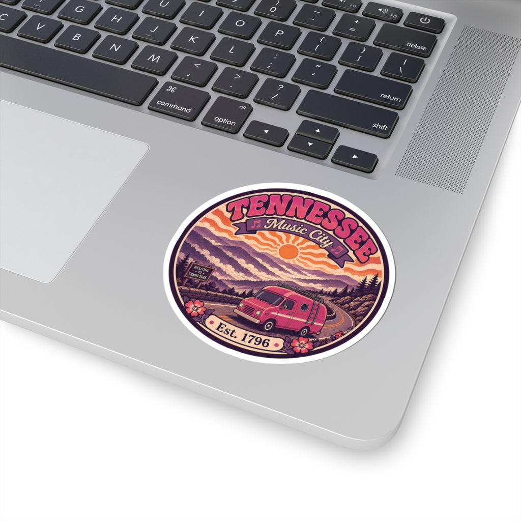 Round sticker on laptop lid: Tennessee Music City, pink van and mountains, Est. 1796