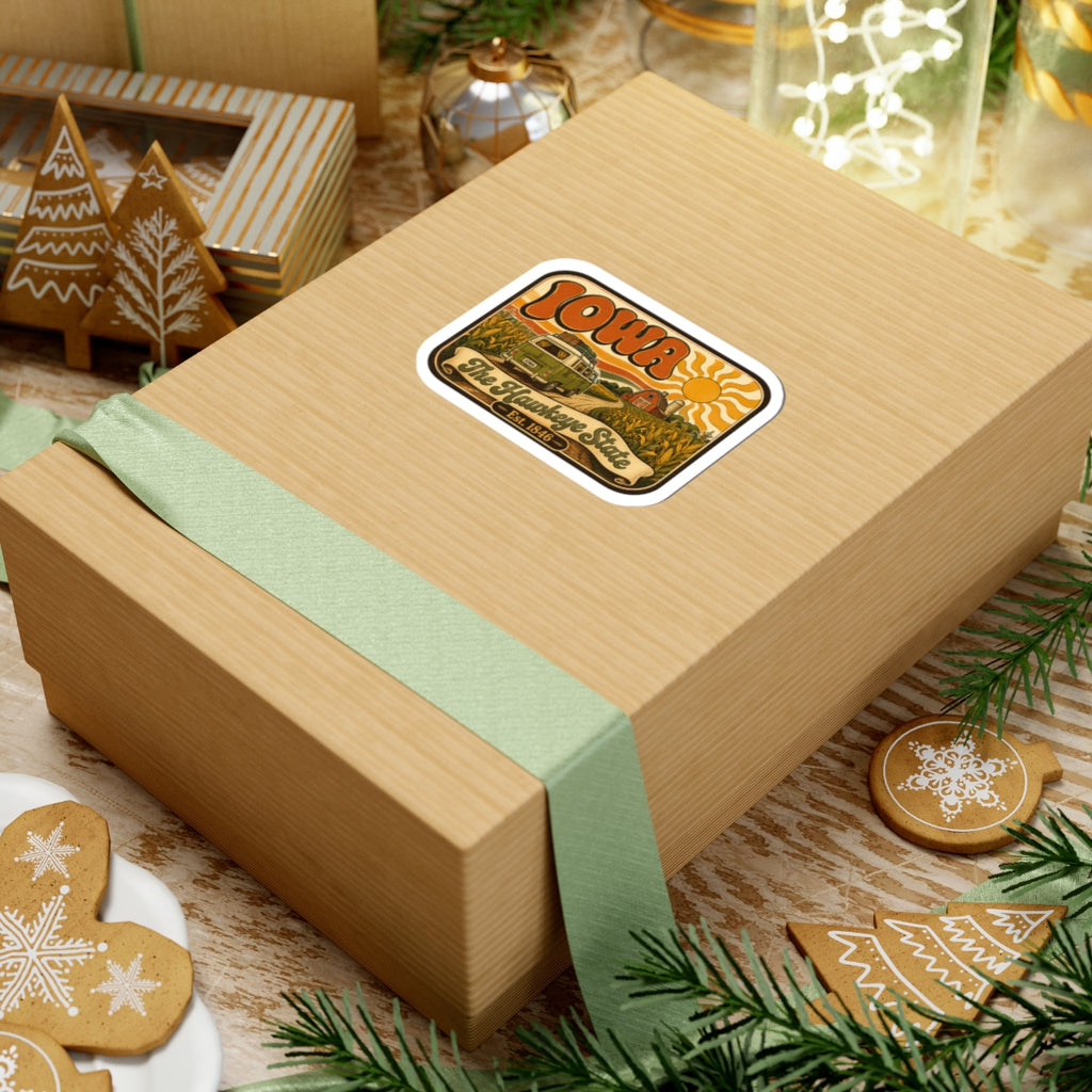 Kiss-cut Iowa retro camper sticker on gift box; orange “Iowa” and camper scene, white border