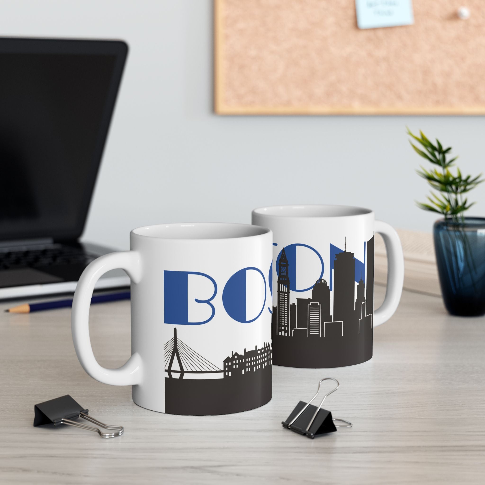 Two white ceramic mugs with blue BOS lettering and black city skyline design
