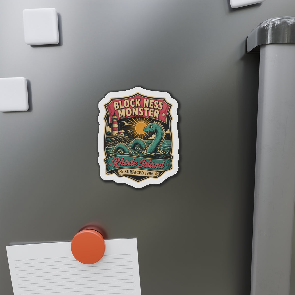 Die-cut magnet sticker on stainless fridge door with teal sea monster and Rhode Island text