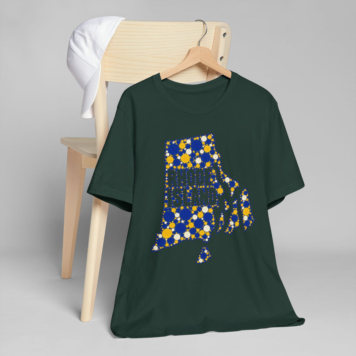 Dark green T-shirt with blue and yellow dotted Rhode Island outline graphic on chest