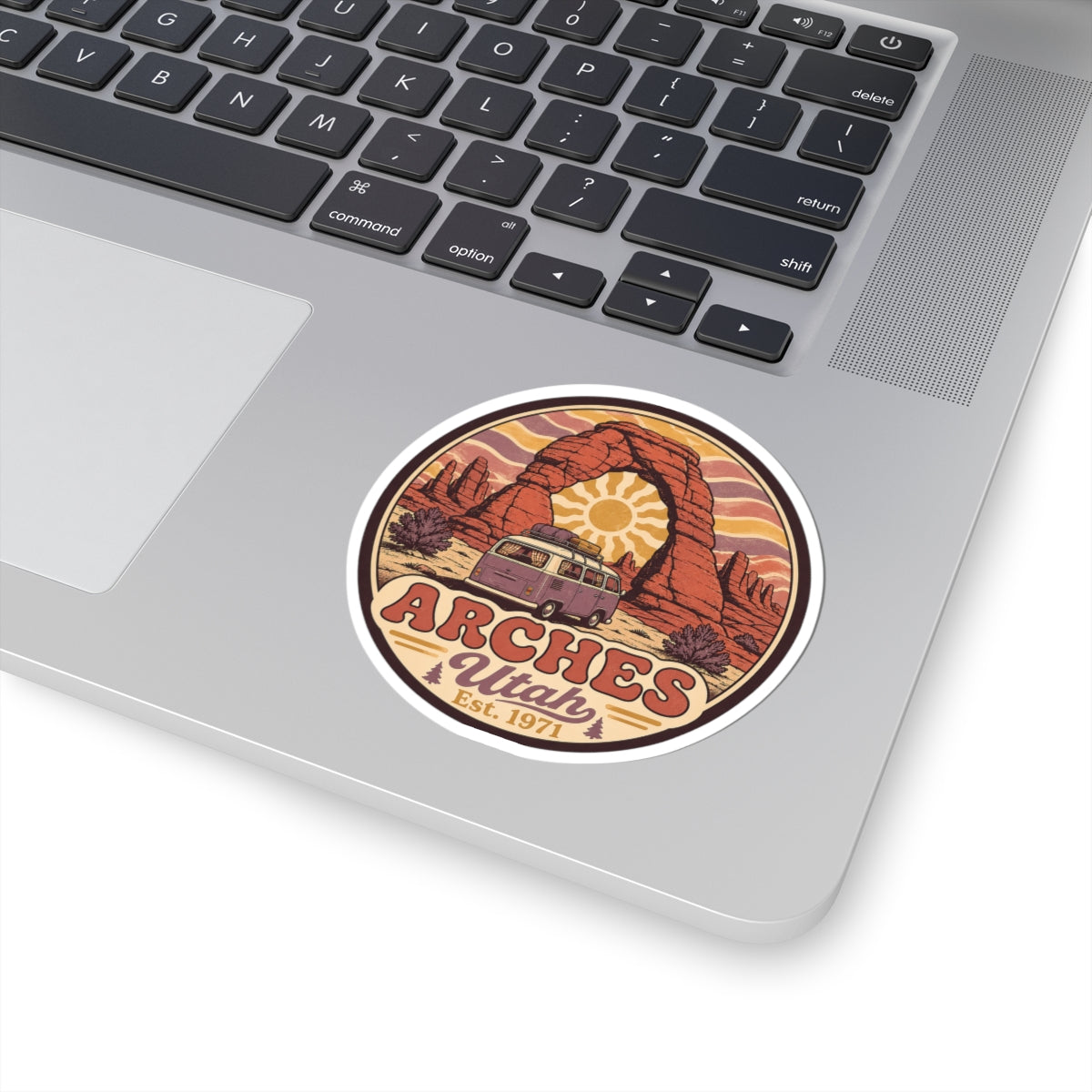 Round sticker featuring a red rock arch, camper van, and "ARCHES Utah" lettering
