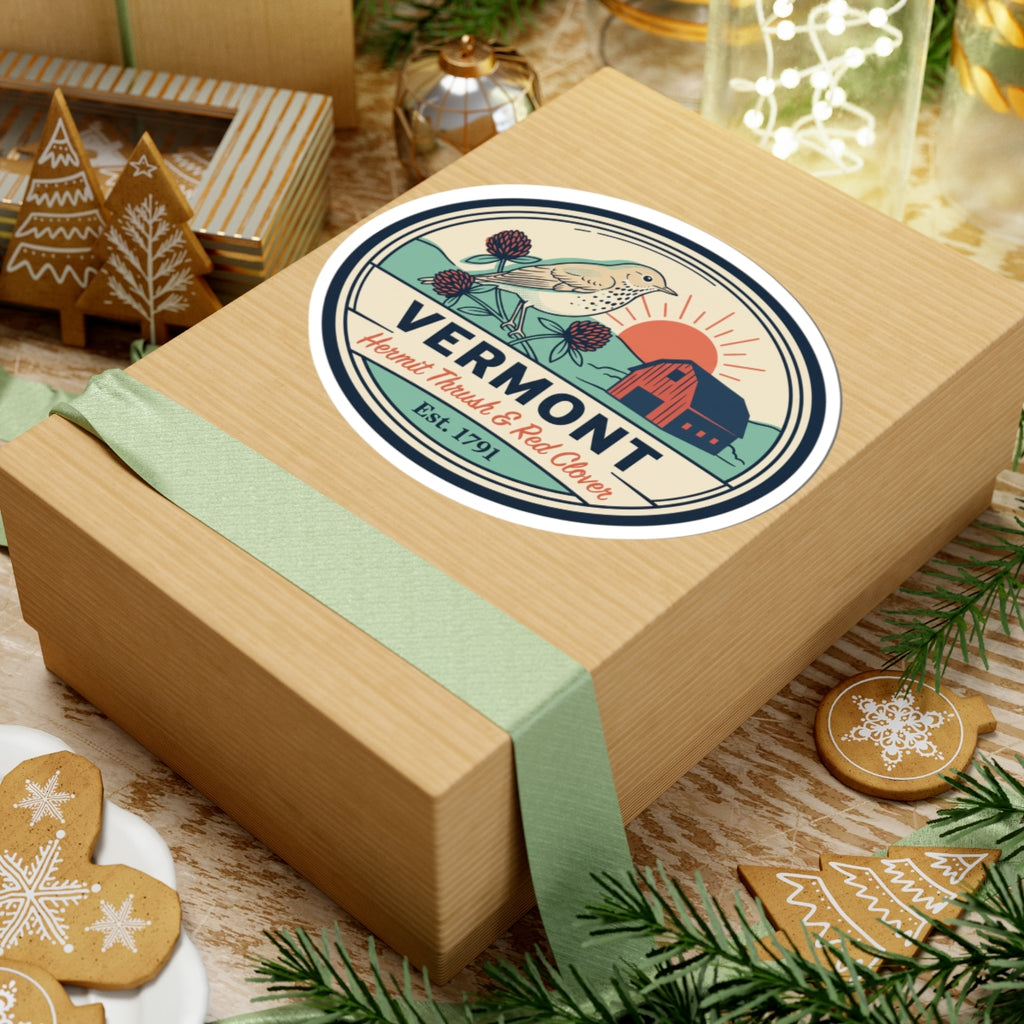 Vermont sticker on wrapped gift box with green ribbon and evergreen decor