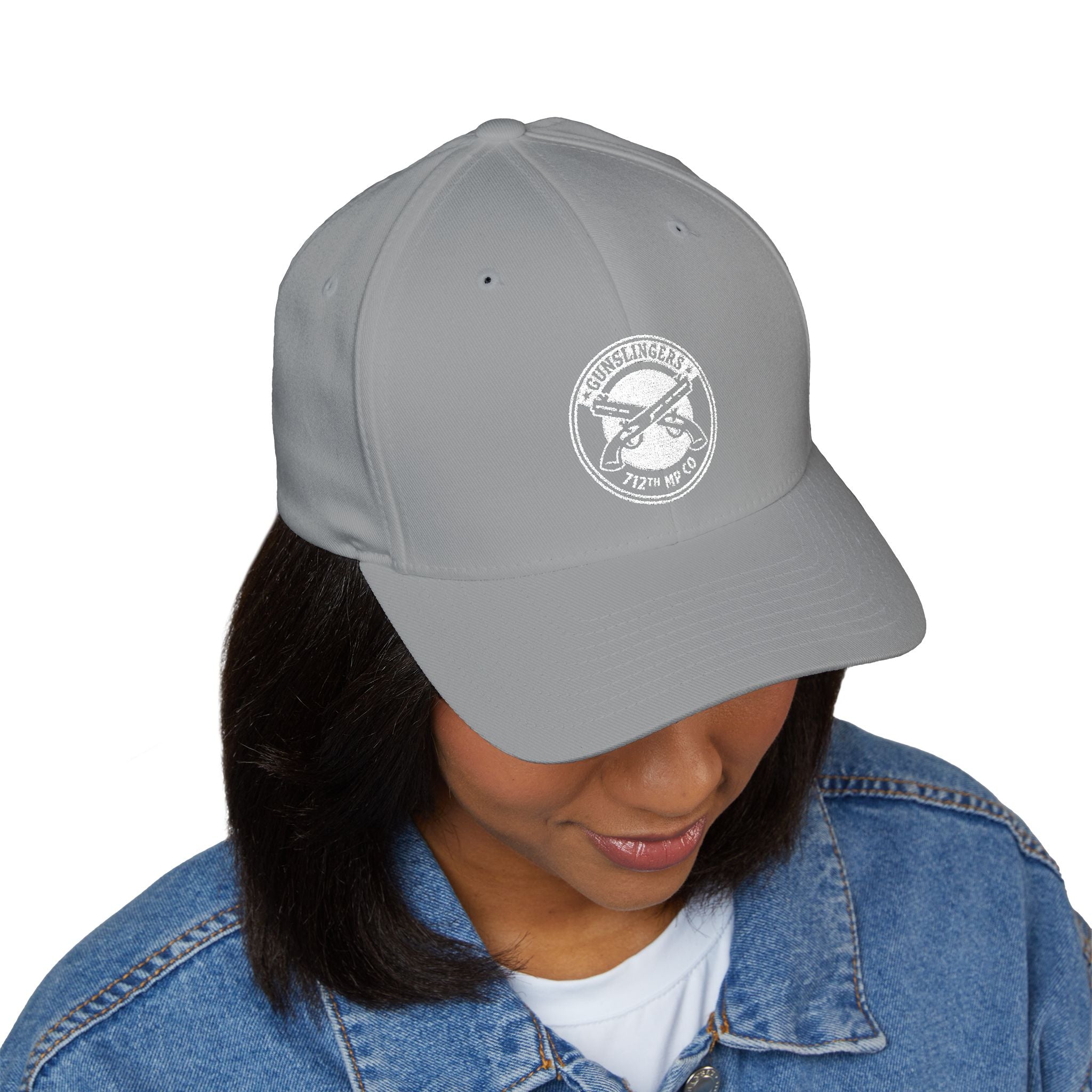 Embroidered baseball cap in light grey with white circular emblem on front panel.