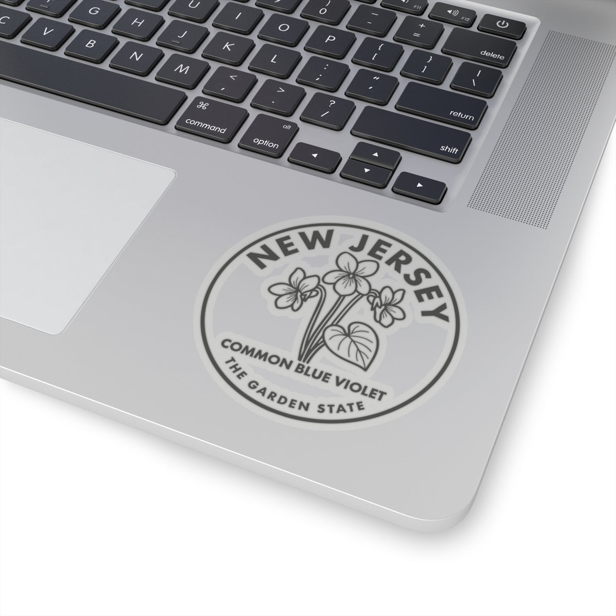 Circular New Jersey common blue violet sticker on laptop surface, visible text and line art