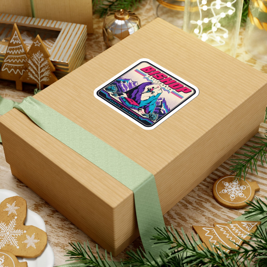 Square kiss-cut sticker with climber artwork, purple boulders, teal plants, pink banner details