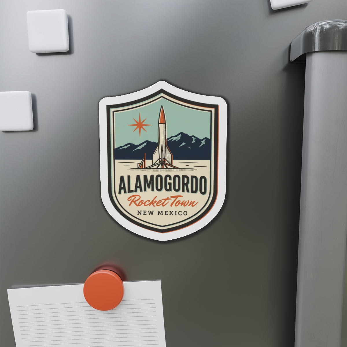 Shield die-cut magnet on stainless steel with rocket and 'Alamogordo RocketTown' text