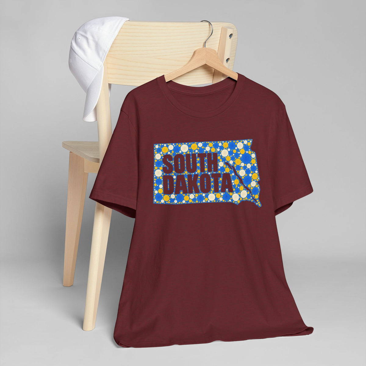 Burgundy crew-neck t-shirt with colorful South Dakota polka-dot map outline graphic.