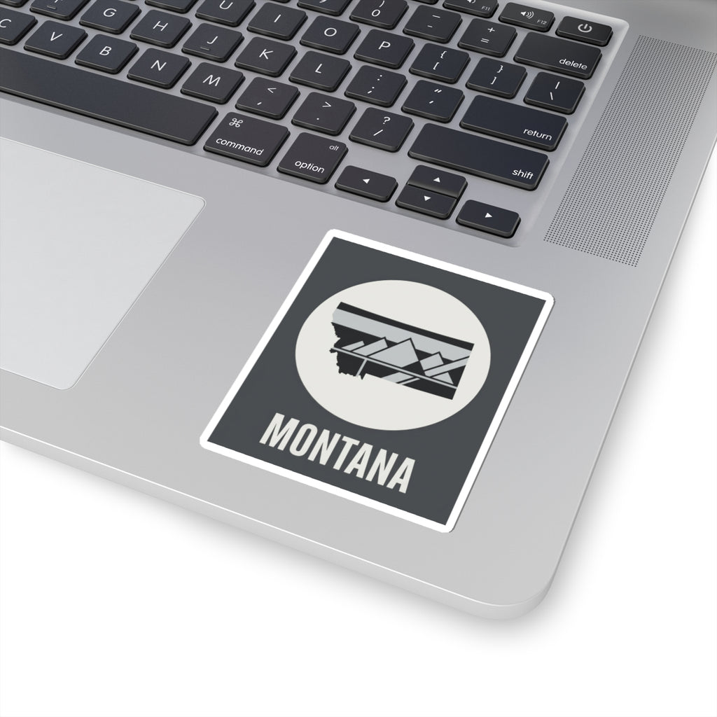 Montana mountain badge sticker on laptop, white circle emblem with landscape graphic and MONTANA text
