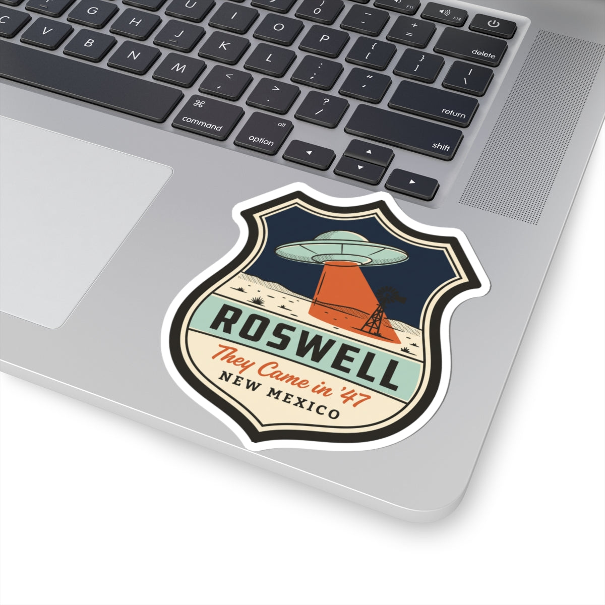 Shield badge kiss-cut sticker with UFO saucer above orange base; “They Came in '47”