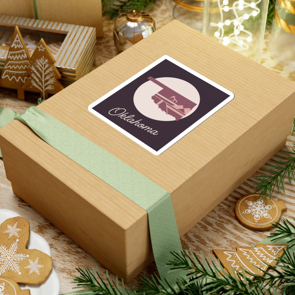 Oklahoma state sticker on wrapped gift: maroon square with oil derrick silhouette and Oklahoma script