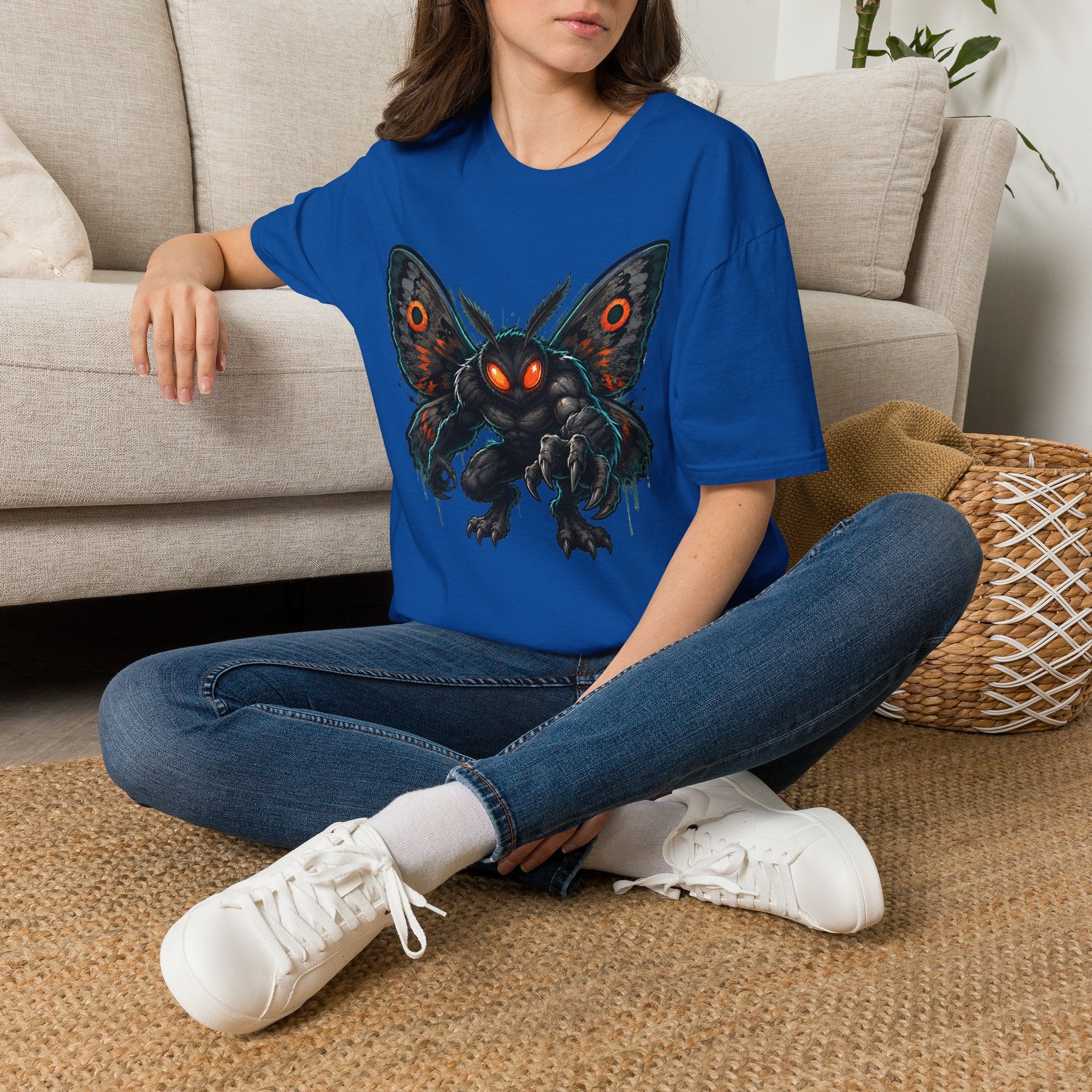 Royal blue monster moth graphic T-shirt with glowing eyes, worn on model