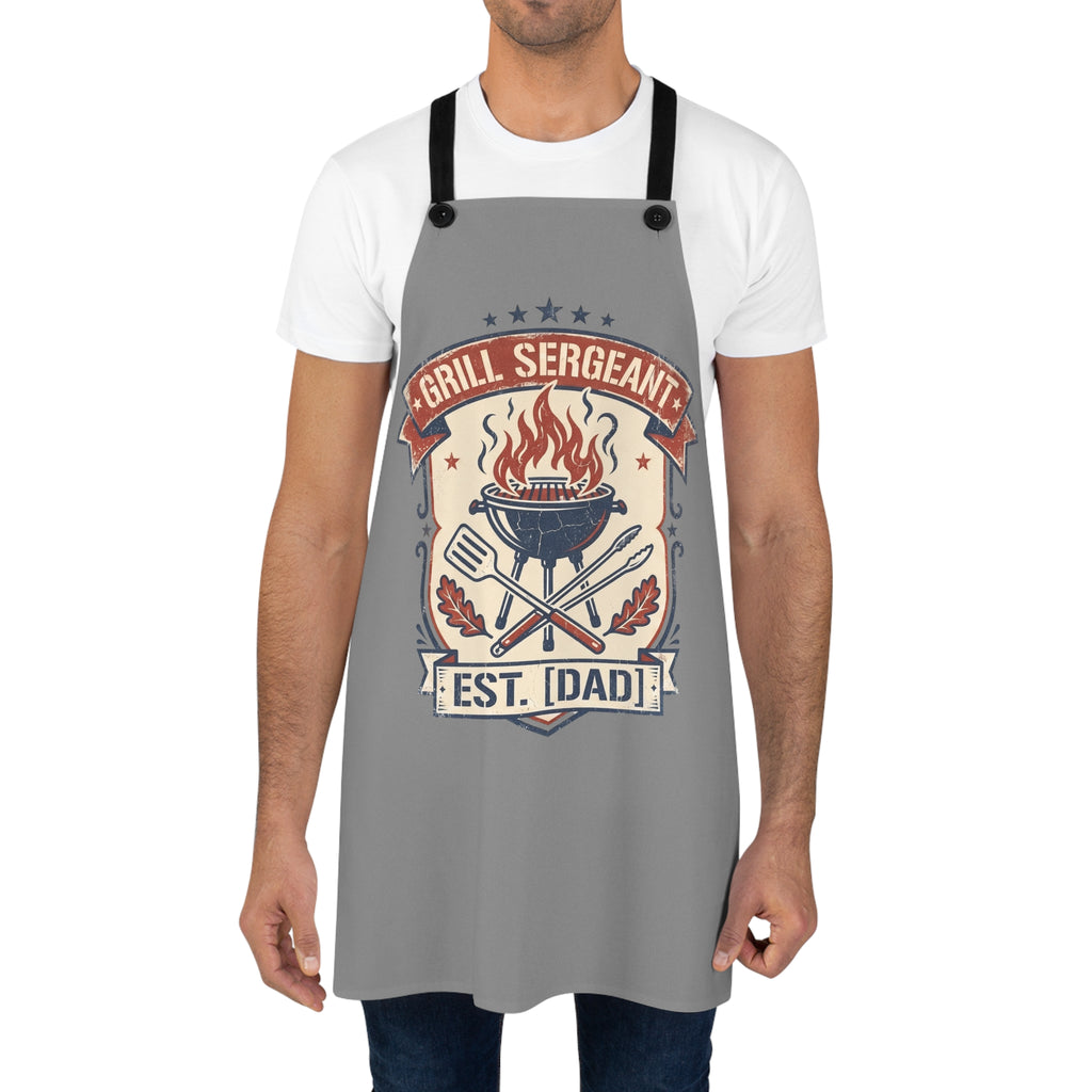 Gray BBQ apron on person with black straps and large flame grill retro badge