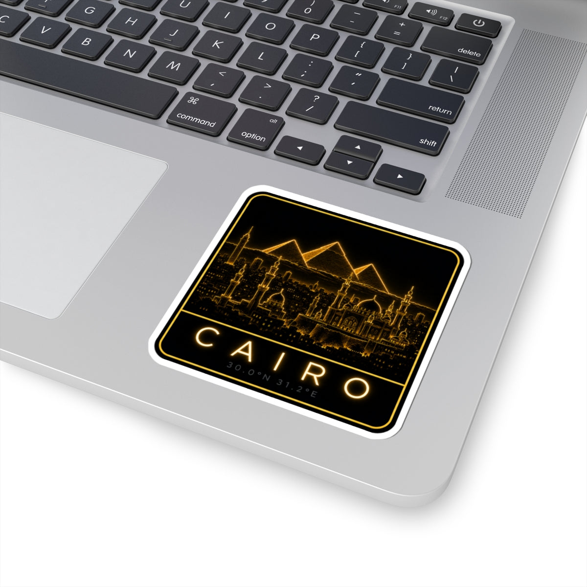 Cairo neon sticker on a laptop keyboard, showing glowing skyline and CAIRO letters