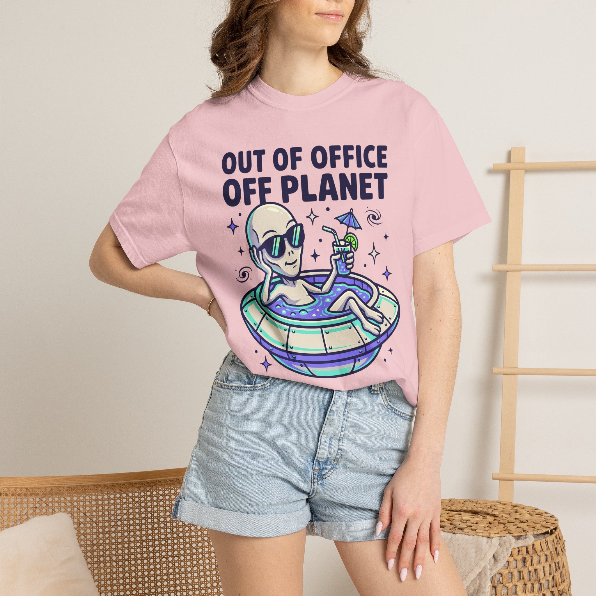 Pink crewneck T-shirt on model, alien floatie graphic and 'OUT OF OFFICE OFF PLANET'