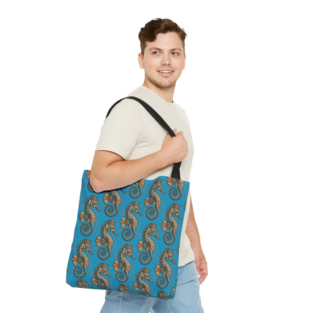 Tote bag worn on shoulder in blue with seahorse pattern and black straps