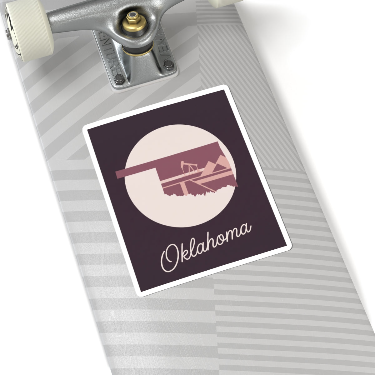 Oklahoma state sticker on striped luggage: maroon square with oil derrick silhouette and Oklahoma