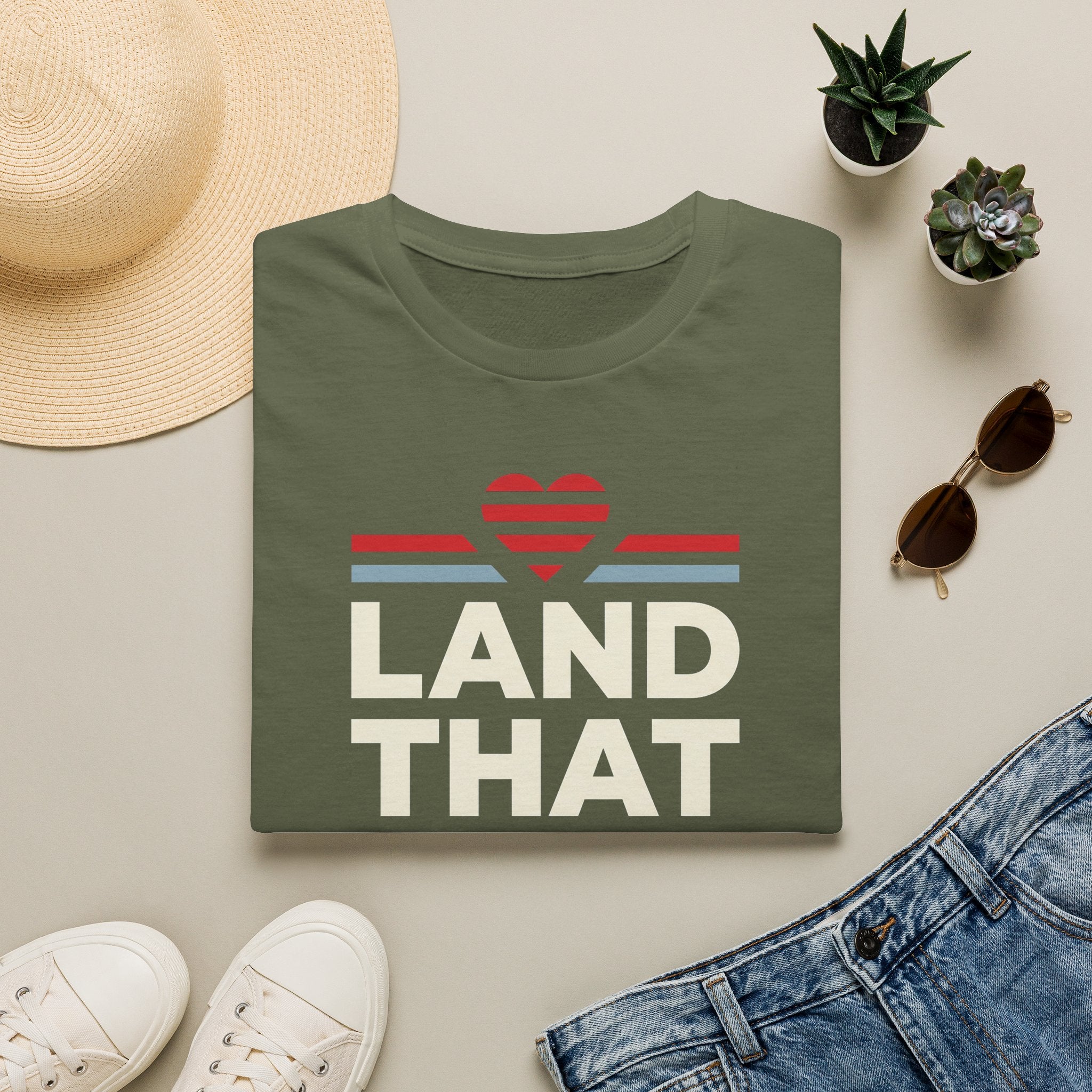 Military green unisex T-shirt with retro heart graphic and text 'LAND THAT'
