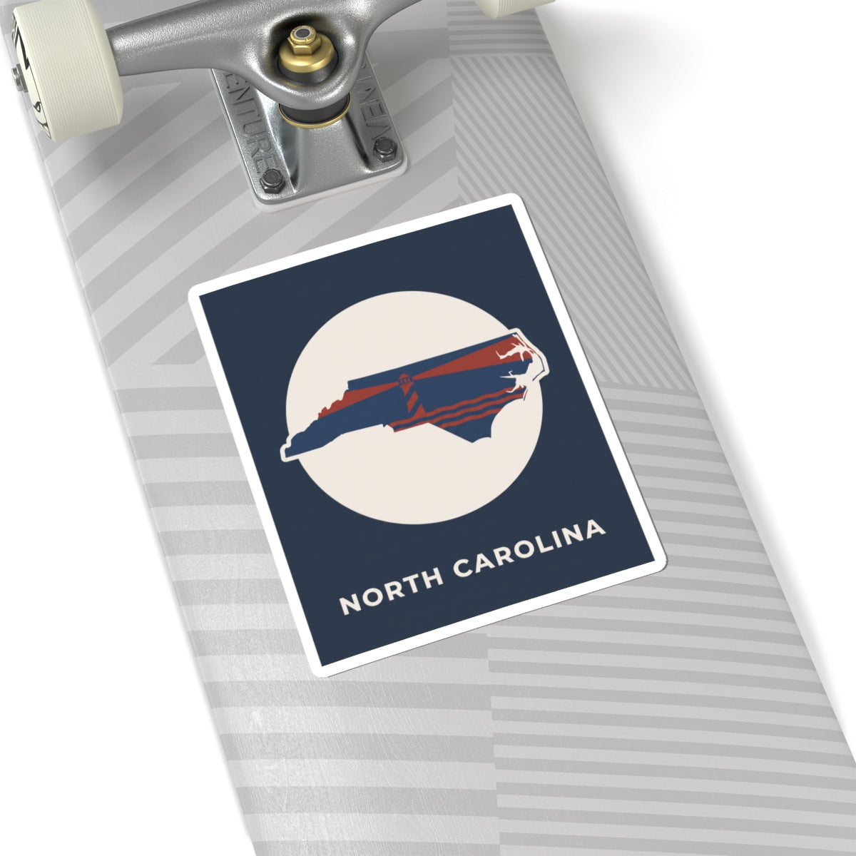 North Carolina map kiss-cut sticker on gray surface, navy square with state graphic