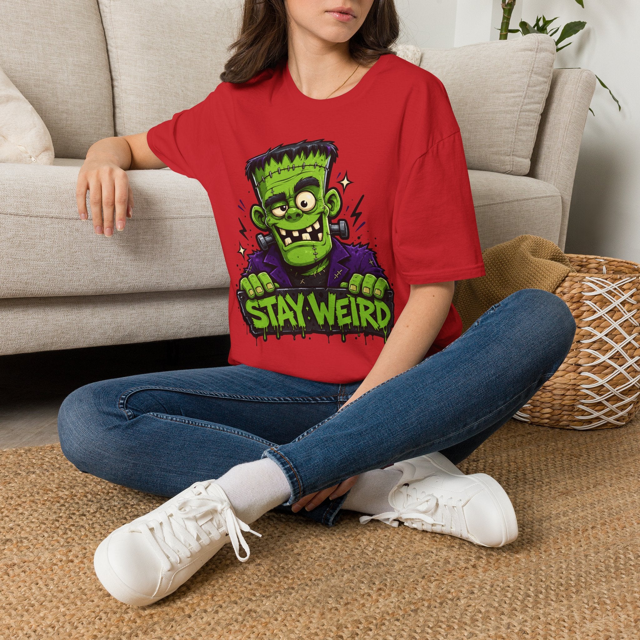 Red crewneck T-shirt with green monster graphic and 'STAY WEIRD' text.